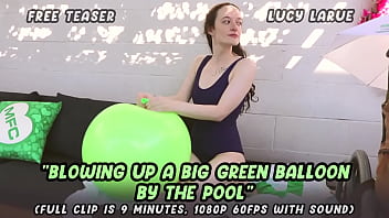Blowing up a big green balloon by the pool