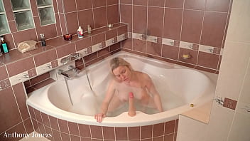 Slut playing with her dildo in her bathtub gets her trhoat fuclked and big load con her slutty face