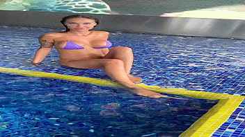 Monika fox in purple bikini swims in pool & poses by window against background of city free