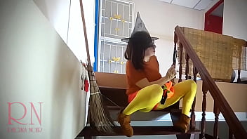 Halloween witch in rtgina noir witch with pumpkins and a broom regina noir velma dinkley yellow pantyhose performing in old house at stairway