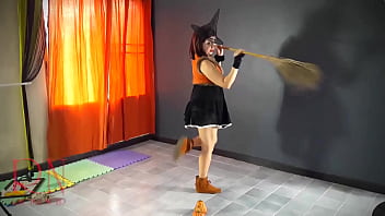 Halloween witch in rtgina noir witch with pumpkins and a broom regina noir velma dinkley yellow pantyhose performing in old house at stairway