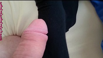 Mit bestrumpften füßen macht sich die junge frau daran mit meinem schwanz zu spielen und ihn zu massieren