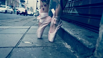 Ballerina wearing ballet shoes and walking down the street
