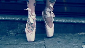 Ballerina wearing ballet shoes and walking down the street