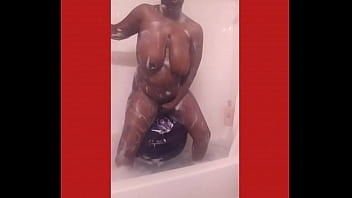 Purple dildo in a tub fill of bubbles