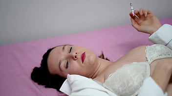 Playful brunette smoking in white blouse and bra