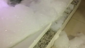 Morena na banheira de espuma sensualizando