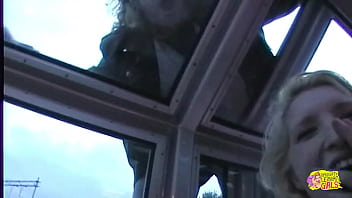 Two women engaged in a provocative display of affection and intimate interaction aboard a vessel situated in the city of paris