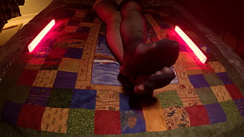 Sensual perfect feet peek through fishnet pantyhose