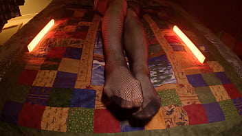 Sensual perfect feet peek through fishnet pantyhose