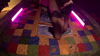 Sensual perfect feet peek through fishnet pantyhose