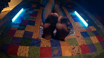 Sensual perfect feet peek through fishnet pantyhose