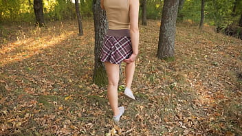 Naughty girl walking in the nature and teasing butt under school skirt