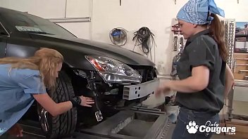 Two horny girls fuck in an auto repair garage