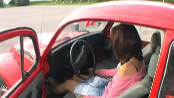 Bimba siting barefoot in her volkswagen car revving the engine