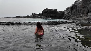 A stepmom practices sucking on a candy on the beach then tests her skills on her stepson's dick