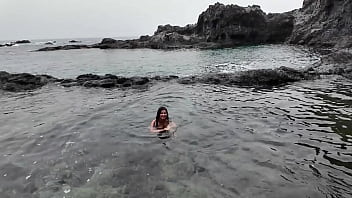 A stepmom practices sucking on a candy on the beach then tests her skills on her stepson's dick