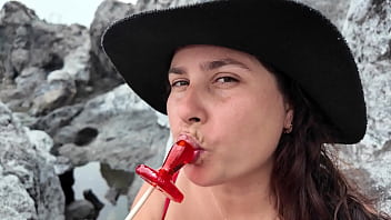 A stepmom practices sucking on a candy on the beach then tests her skills on her stepson's dick