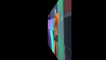 Blonde celeb dances on a table wearing a short skirt while some chap looks up it and the camera wants upskirts too