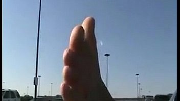 Chick teasing her feet at a parking lot