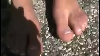 Chick teasing her feet at a parking lot