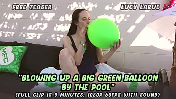 Blowing up a big green balloon by the pool