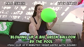 Blowing up a big green balloon by the pool