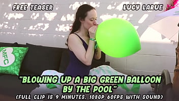 Blowing up a big green balloon by the pool