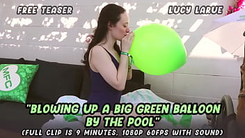 Blowing up a big green balloon by the pool