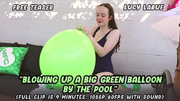 Blowing up a big green balloon by the pool