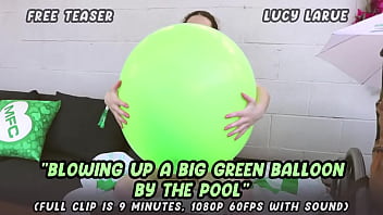 Blowing up a big green balloon by the pool