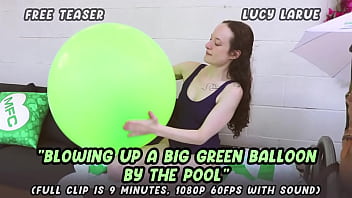 Blowing up a big green balloon by the pool