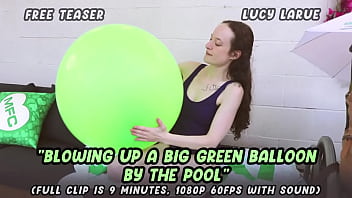 Blowing up a big green balloon by the pool