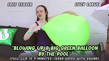 Blowing up a big green balloon by the pool