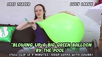 Blowing up a big green balloon by the pool