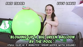 Blowing up a big green balloon by the pool