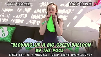 Blowing up a big green balloon by the pool