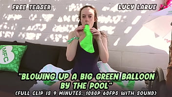 Blowing up a big green balloon by the pool
