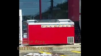 Gas station employee cleaning a cooler