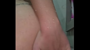 A água escorre mas o que molha de verdade é a boceta latejando de tesão ela enfia o consolo transparente sem dó se arrebentando de prazer enquanto geme e se contorce