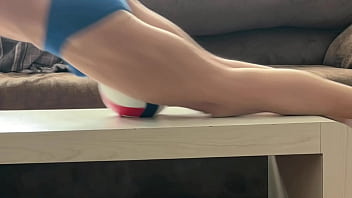 On the table in tight briefs with volleyball for muscle compression and myofascial unwinding clips