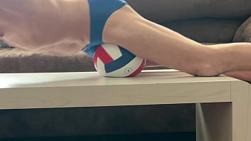 On the table in tight briefs with volleyball for muscle compression and myofascial unwinding clips