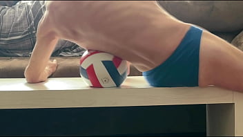 On the table in tight briefs with volleyball for muscle compression and myofascial unwinding clips