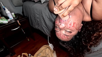 Bbw colored girl deepthroating a dildo after writing dirty words on her whore face