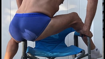 Deep pelvic stretching in blue briefs on blue chair late october 2024