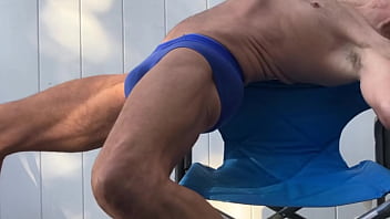 Deep pelvic stretching in blue briefs on blue chair late october 2024