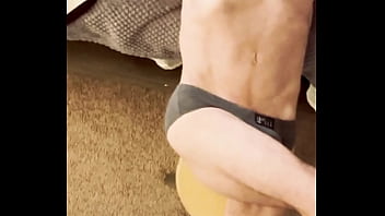 Sneak peak from above stretching in grey briefs on stool and bed