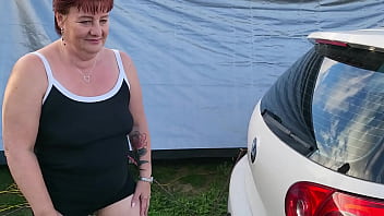 Trashy milf slut pees on the grass in front of other campers at the beach