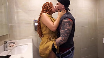 Distracted busty redhead ends up in the men's bathroom and can't resist seeing a big dick