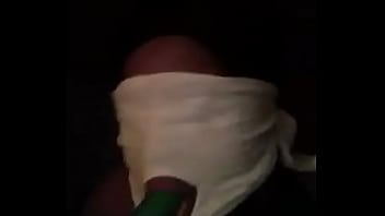 Sucking on a green dildo with mouth mask